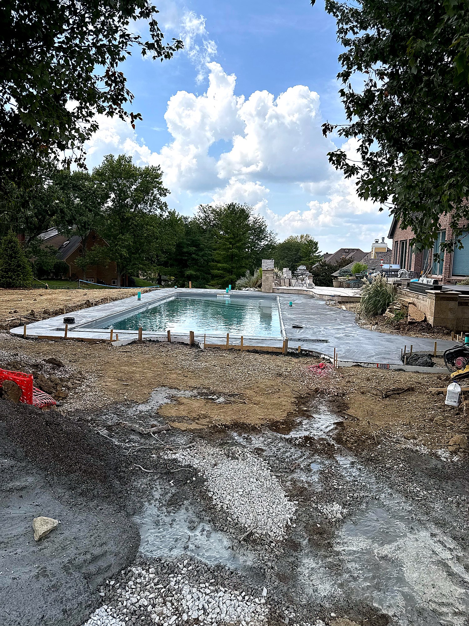 Fresh concrete deck pour around fiberglass pool