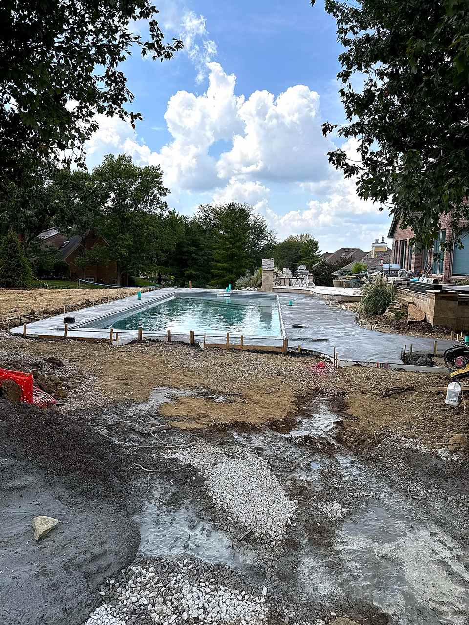 Fresh concrete deck pour around fiberglass pool